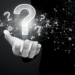 A black and white image of an open white hand and a graphic of a question mark floating above it