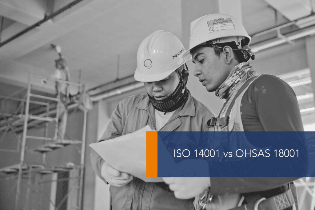 ISO 14001 vs OHSAS 18001 MAIN Two people in PPE looking at paper