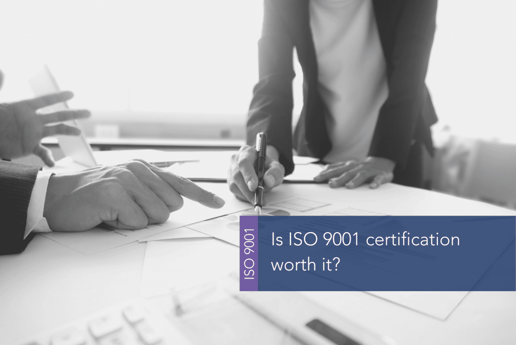 Is ISO 9001 certification worth it MAIN people sitting at a table and writing on paper with pens on it