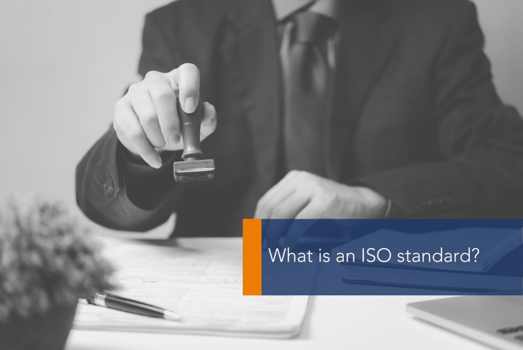 What is an ISO standard MAIN a man is showing off a stamp on his desk with a book and pen in front of him