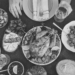 Table filled with food surrounded with hands